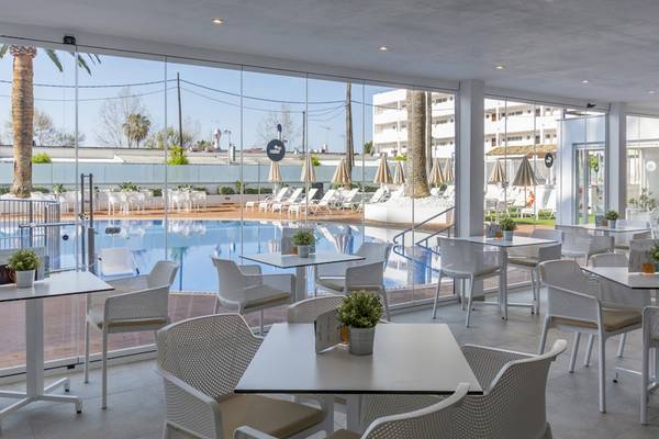 Innenansicht der Terrasse des HSM Linda Playa Hotels mit Tischen, Stühlen und Swimmingpool im Hintergrund.