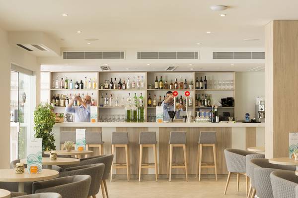 Barbereich im HSM Linda Playa Hotel mit Barkeepern und gefüllten Regalen.