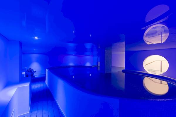 Innenansicht des Schwimmbeckens im HSM Linda Playa Hotel mit blauer Beleuchtung und modernem Design.