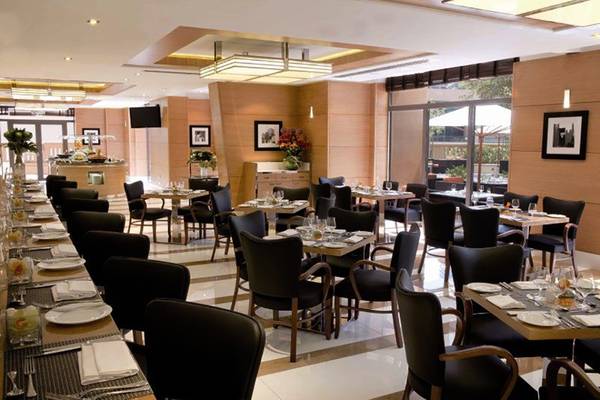 Innenbereich des Restaurants im Delta Hotels by Marriott Jumeirah Beach, Dubai mit gedeckten Tischen und Stühlen.