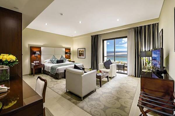 Hotelzimmer im Delta Hotels by Marriott Jumeirah Beach, Dubai mit Bett, Sitzbereich, Fernseher und Meerblick.