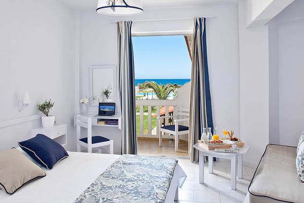 Zimmer im Mrs Chryssana Beach Hotel mit Balkon, Schreibtisch und Meerblick.