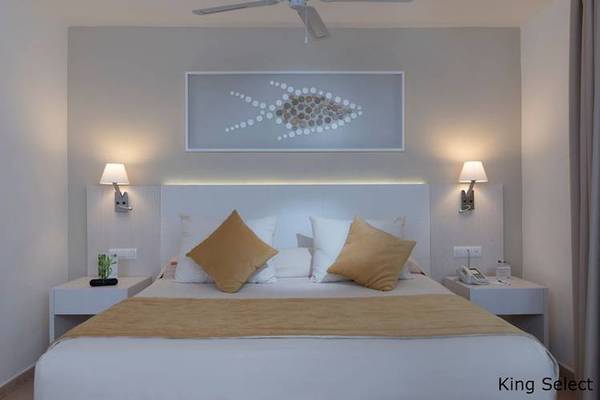 Hotelzimmer im Dreams Flora Resort & Spa mit King-Size-Bett, Wandkunst und Nachttischen