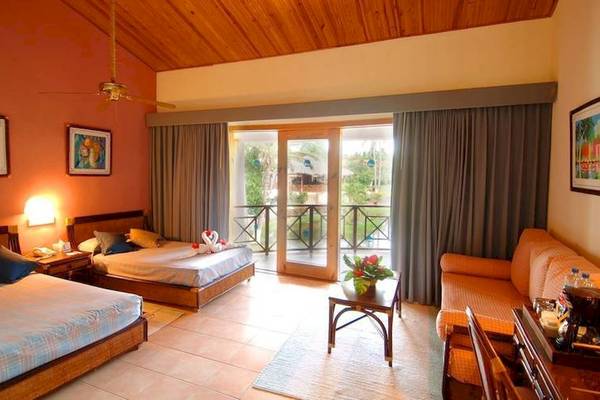 Zimmer im Dreams Flora Resort & Spa mit zwei Betten, Sofa, Tisch und Balkon