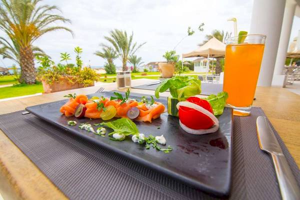 Frühstücksplatte mit Lachs, Salat und Getränk auf dem Tisch im Freien im Golden Tulip Taj Sultan