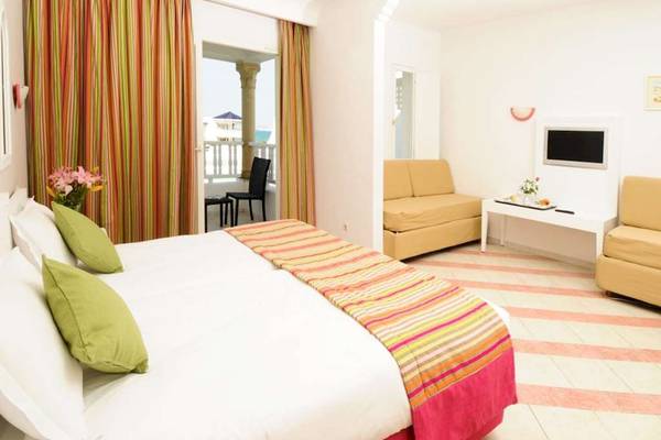 Hotelzimmer im Golden Tulip Taj Sultan mit Bett, Balkon und Fernseher