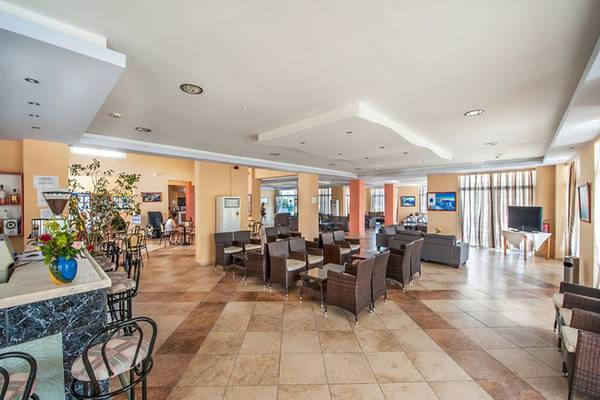 Lobby des Pyli Bay Hotels mit Sitzbereichen und Dekoration.