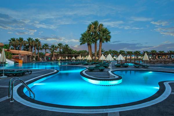 Pool im Megasaray Club Belek bei Nacht mit blau beleuchtetem Wasser und Sonnenliegen.