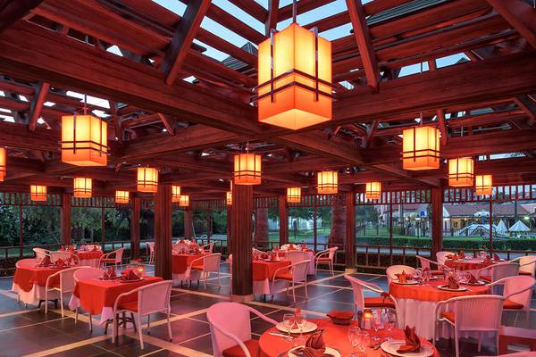 Restaurantbereich im Megasaray Club Belek mit roten Tischen und hängenden Laternen.