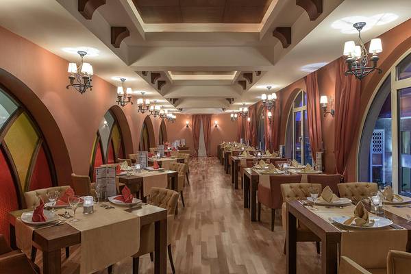 Innenansicht des Restaurants im Megasaray Club Belek mit gedeckten Tischen und dekorativen Kronleuchtern.