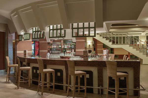 Innenansicht der Bar im Megasaray Club Belek Hotel mit Tresen, Stühlen und Getränken.