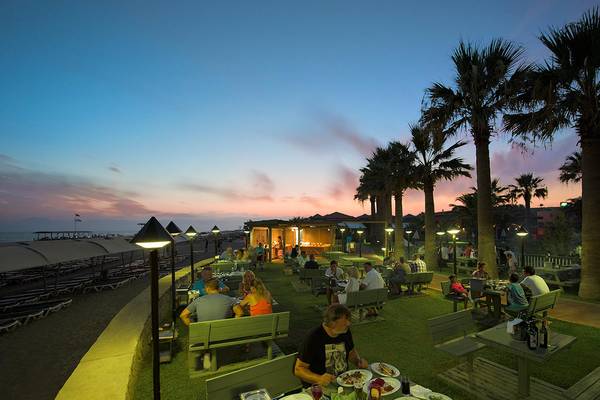 Gäste essen auf der Terrasse des Megasaray Club Belek bei Sonnenuntergang.