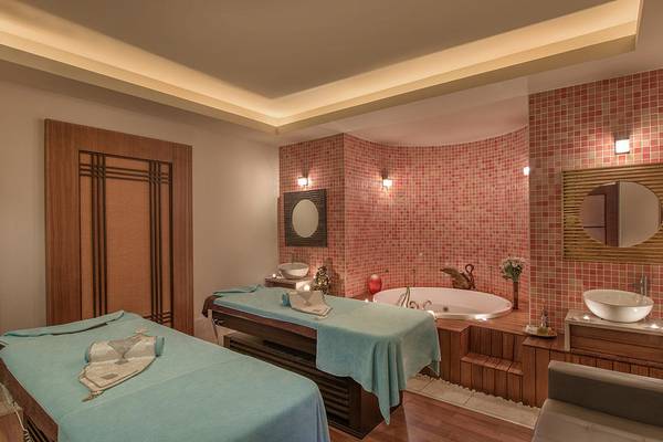 Spa-Bereich im Megasaray Club Belek mit zwei Massagetischen, Badewanne und roten Fliesenwänden.