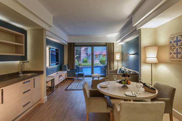 Innenansicht einer Suite im Megasaray Club Belek mit Essbereich und Swimmingpoolsicht.
