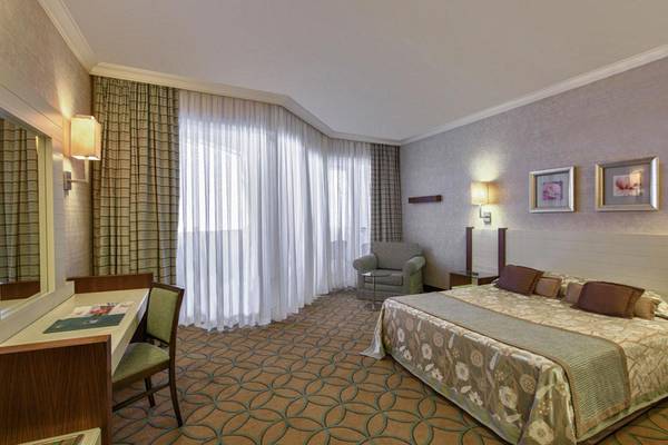 Doppelbettzimmer im Megasaray Club Belek Hotel mit Schreibtisch, Sessel und großen Fenstern.