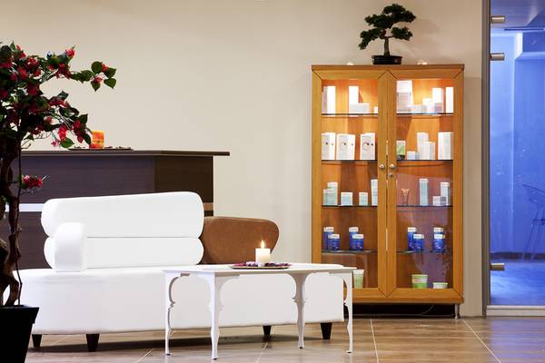Empfangsbereich des Lesante Classic Luxury Hotel & Spa mit weißem Sofa, Tisch und Glasschrank.
