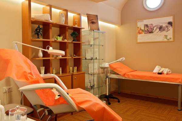 Behandlungsraum im Lesante Classic Luxury Hotel & Spa mit orangefarbenen Stühlen und Behandlungstischen.