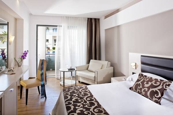 Innenansicht einer Suite im Lesante Classic Luxury Hotel & Spa mit Bett, Sessel und Schreibtisch.