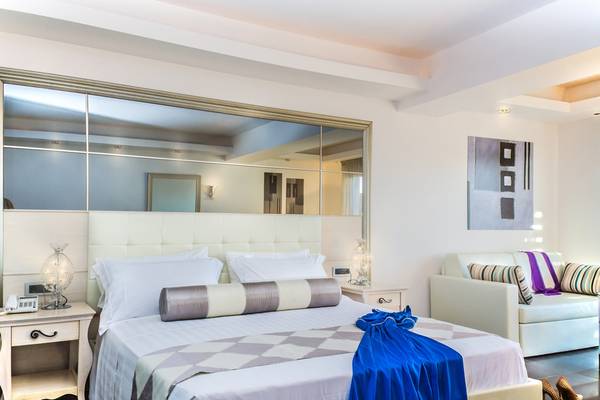 Luxuriöses Zimmer im Lesante Classic Luxury Hotel mit Bett, Spiegel und Sofa.