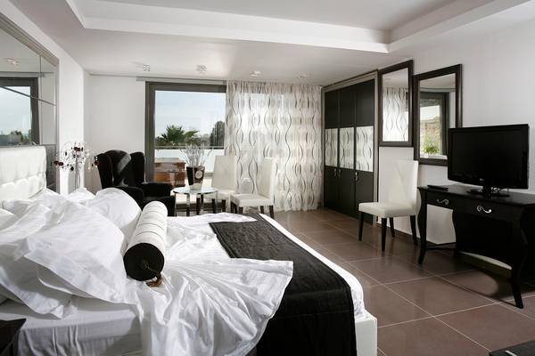 Schlafzimmer im Lesante Classic Luxury Hotel mit einem großen Bett, weißen Kissen und einer schwarzen Decke.