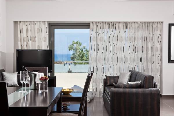 Wohnzimmer mit Tisch, Sofa, Fernseher und Meerblick