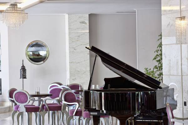 Loungebereich im Lesante Classic Luxury Hotel mit Klavier, Stühlen und Tisch.