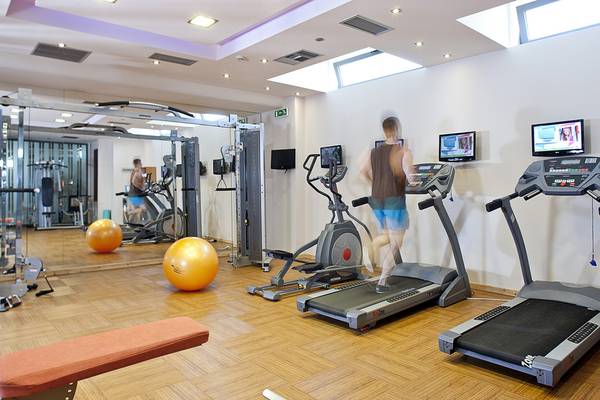 Fitnessstudio im Lesante Classic Luxury Hotel & Spa mit einem Mann, der auf einem Laufband läuft.