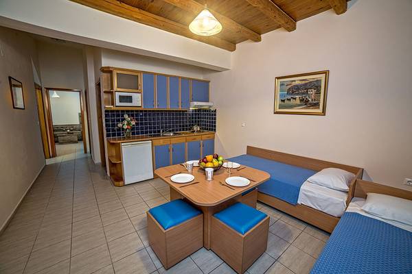 Suite-Zimmer im Blue Aegean Hotel mit Küchenbereich, Esstisch und zwei Betten.