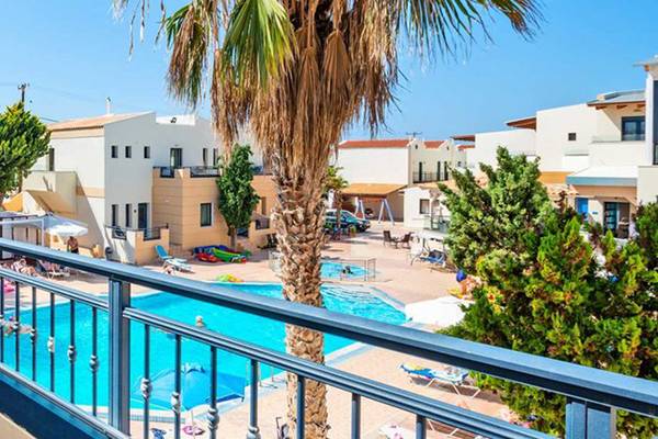 Aussicht auf das Blue Aegean Hotel & Suites mit Swimmingpool und Liegestühlen.