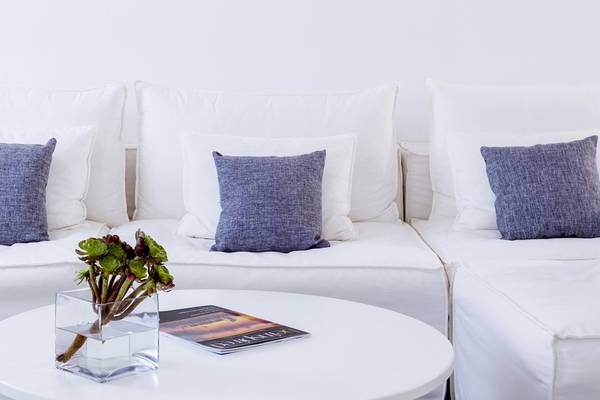 Wohnbereich im Pietra E Mare Mykonos Hotel mit einem weißen Sofa und Kissen.