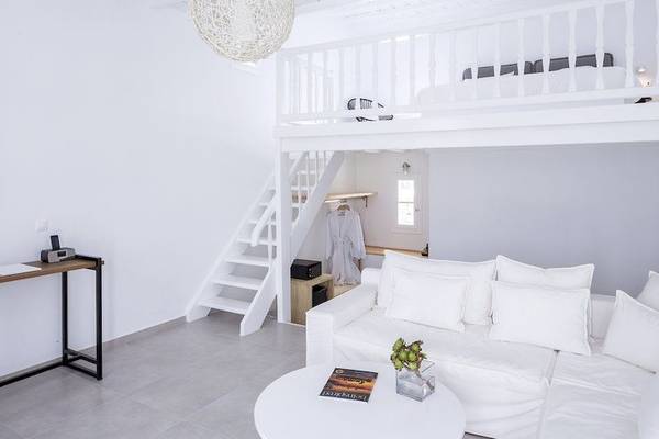 Weißes Zimmer im Pietra E Mare Mykonos Hotel mit Schlafbereich, Couch und Treppe