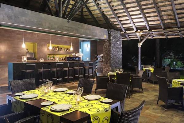 Innenbereich des Restaurants im Barcelo Margaritas Hotel mit Tischen und Stühlen, einer Bar und einer Decke.
