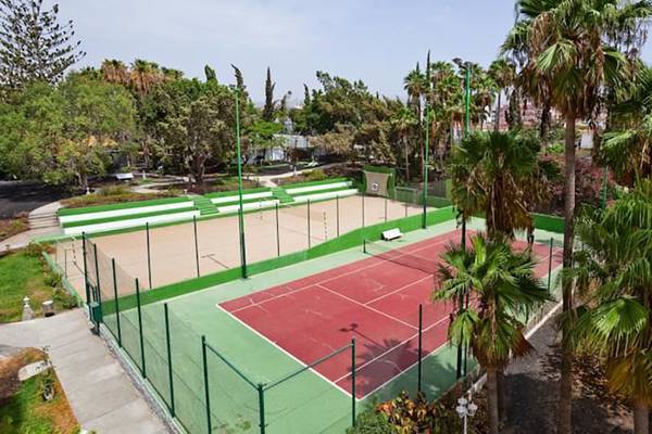 Tennisplatz im Freien des Barcelo Margaritas Hotels mit roten und grünen Feldern und Palmen.