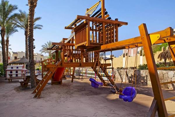 Spielplatz im DoubleTree by Hilton Sharks Bay Resort mit Holzstruktur und Schaukeln.