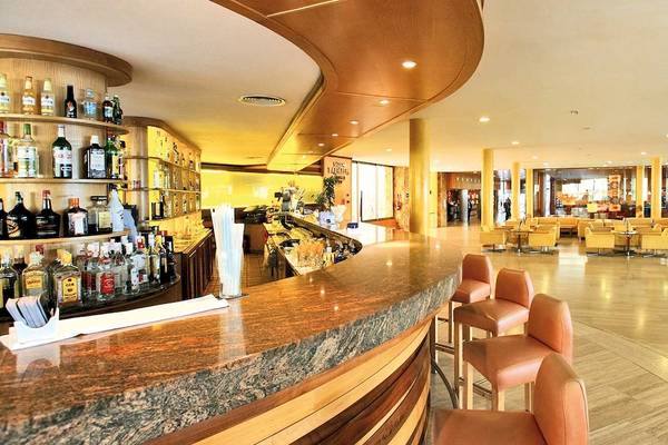 Die Lobbybar des Barcelo Fuerteventura Mar Hotels mit einer großen Auswahl an Getränken und gepolsterten Stühlen.