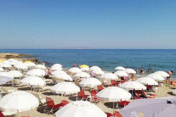 Strand des Blue Aegean Hotel mit vielen Sonnenschirmen und Gästen am Meer