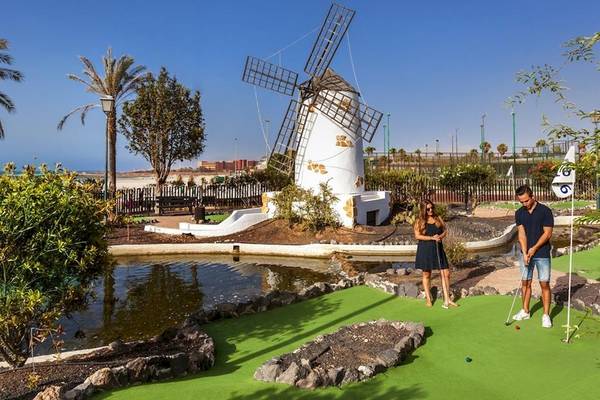 Golfplatz mit einem Paar, das vor einer Mühle spielt, im Freien.