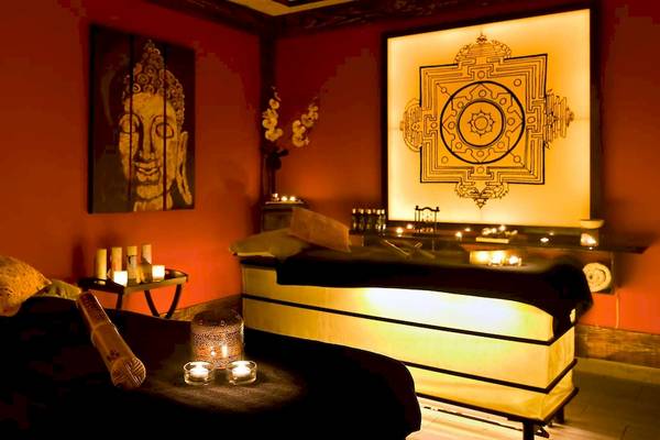 Wellnessbereich im Barcelo Fuerteventura Mar Hotel mit roten Wänden, Kerzen und einem Buddha-Gemälde.