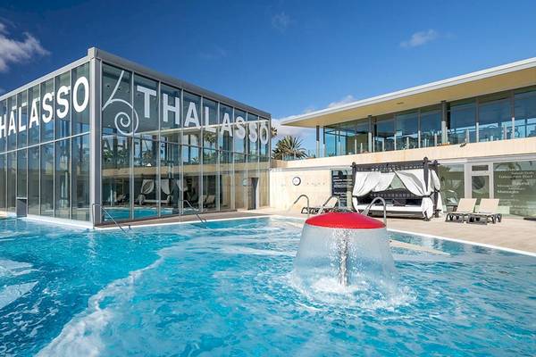 Außenpool des Barcelo Fuerteventura Mar Thalasso Hotels mit modernem Glasgebäude im Hintergrund.
