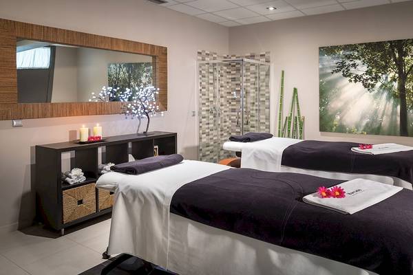 Spa-Behandlungsraum im Barcelo Fuerteventura Mar Hotel mit zwei Behandlungstischen, Kerzen und einem großen Gemälde.