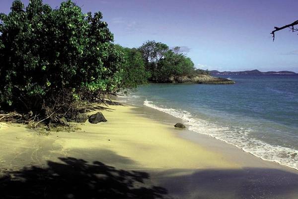 Strand mit karibischem Hotel im Hintergrund und blauem Wasser