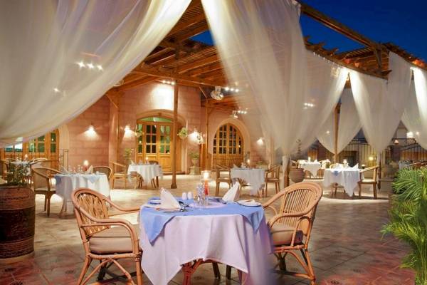 Außenbereich des Akassia Swiss Resort Restaurants mit weißen Tischen und Stühlen.