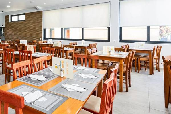 Restaurant des Blue Aegean Hotel & Suites mit vielen Holztischen und Stühlen.
