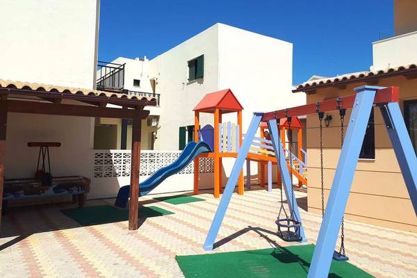 Kinderspielplatz im Blue Aegean Hotel & Suites mit Rutsche und Schaukeln.