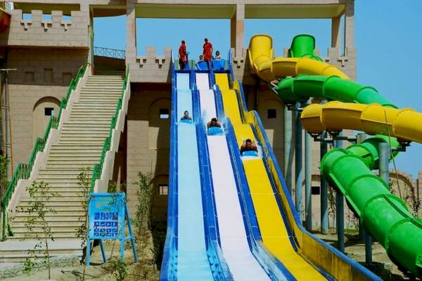 Wasserrutsche im Akassia Swiss Resort mit mehreren Personen, die die Rutschen hinunterrutschen.