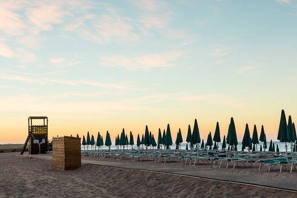 Strandszene mit Sonnenliegen und grünen Sonnenschirmen vor dem Club Hotel Marina Beach.