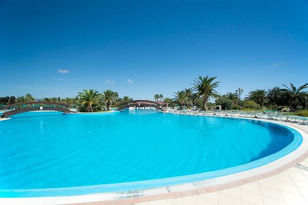 Außenbereich des Club Hotel Marina Beach mit einem großen Pool und Sonnenliegen.