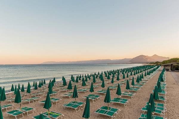 Strand des Club Hotel Marina Beach mit vielen Sonnenschirmen und Liegen.