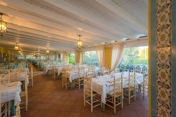 Foto von einem Restaurantbereich im Club Hotel Marina Beach mit vielen gedeckten Tischen und Stühlen.