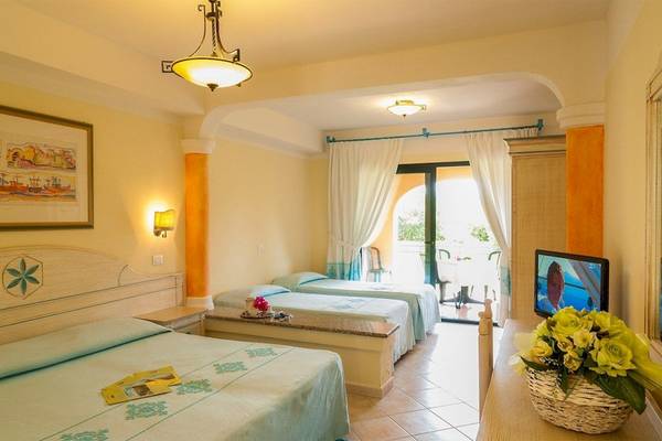 Doppelzimmer im Club Hotel Marina Beach mit zwei Betten, Fernseher, und einem Tisch mit Blumen